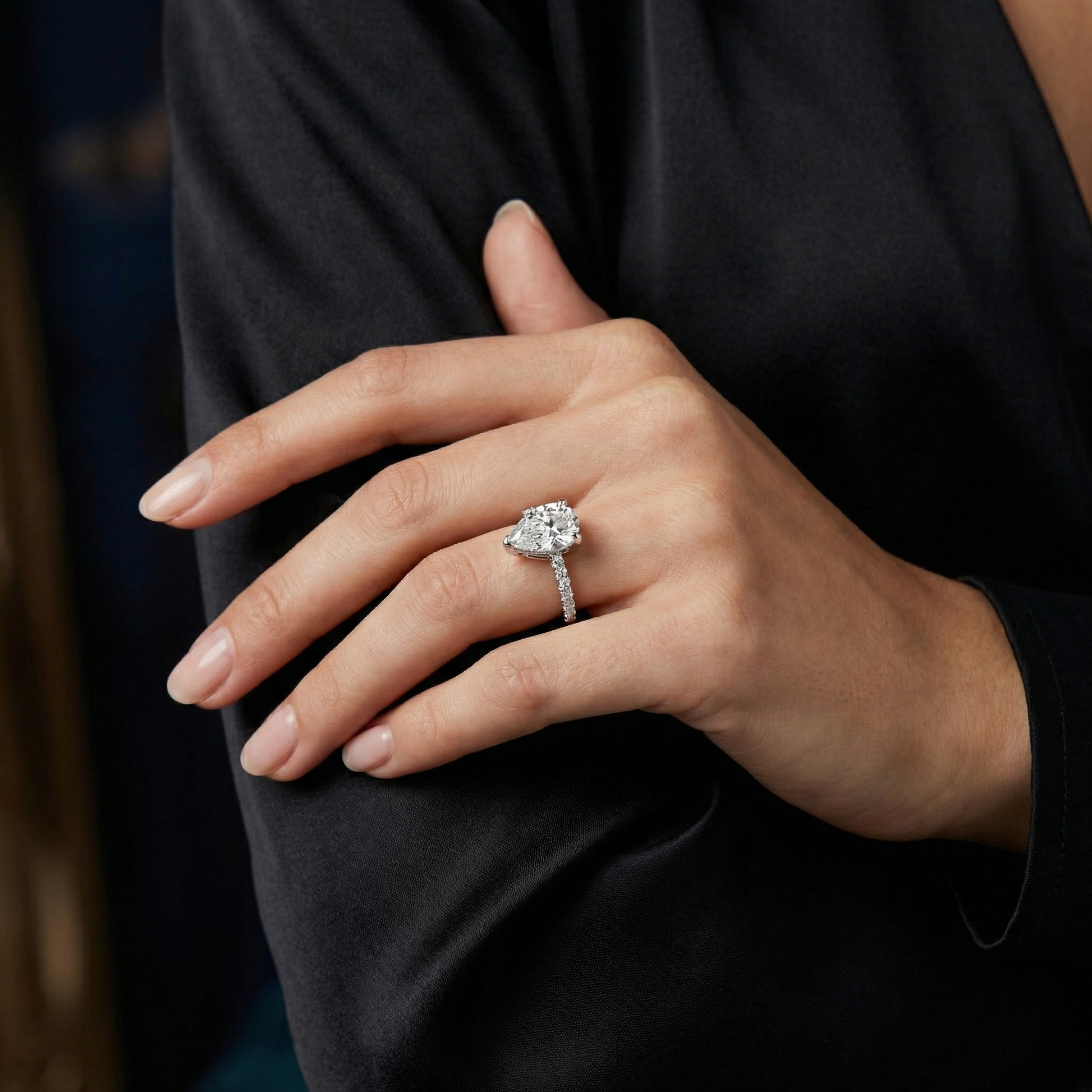 Pear-shaped Solitaire Moissanite Engagement Ring Featuring a Delicate Pave Band